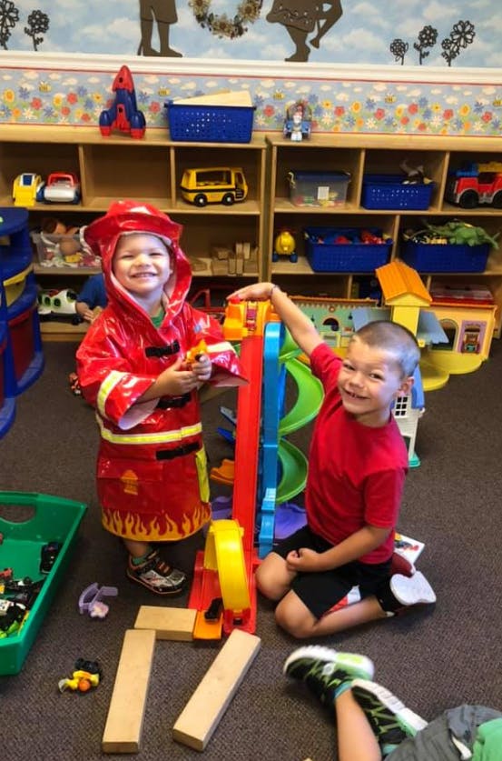Two children playing with toys in a classroom