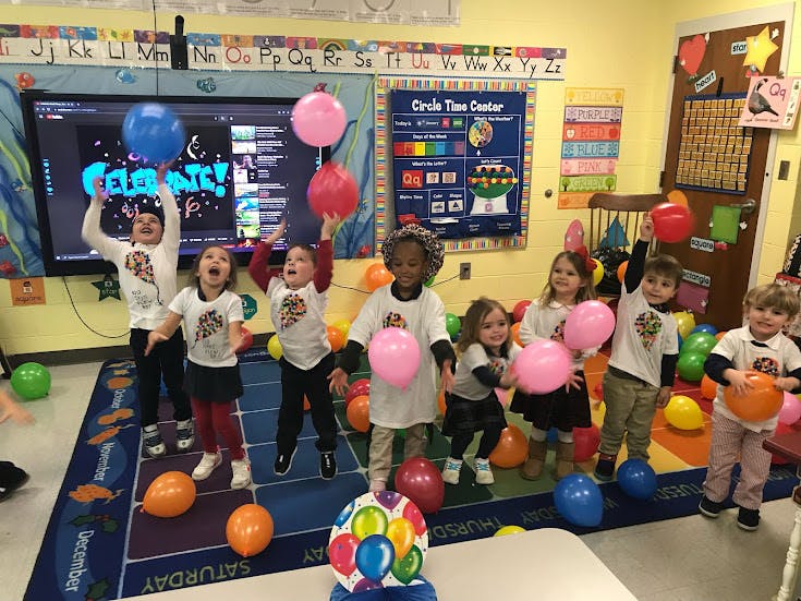 Children playing with balloons in a classroom
