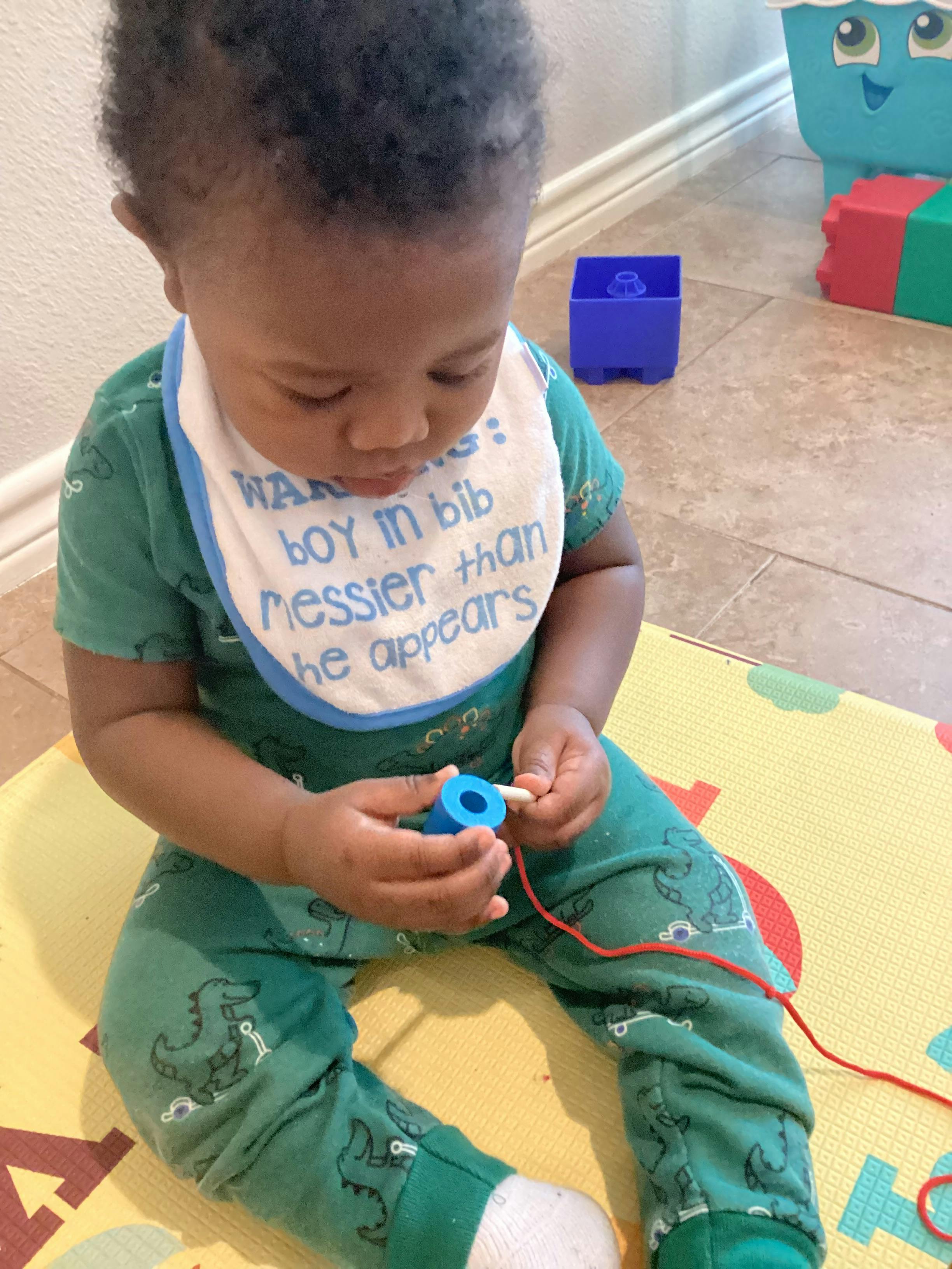 Child playing with a lacing toy