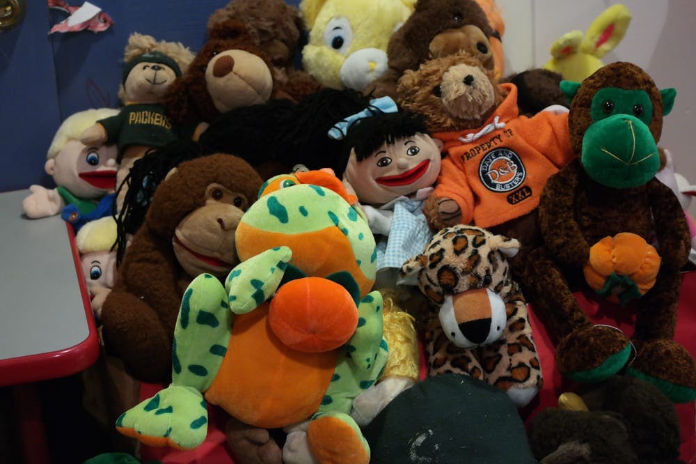 Pile of various stuffed animals including a frog, monkey, and leopard