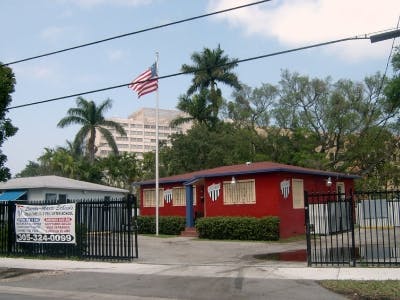 Red building with an American flag on a pole in front