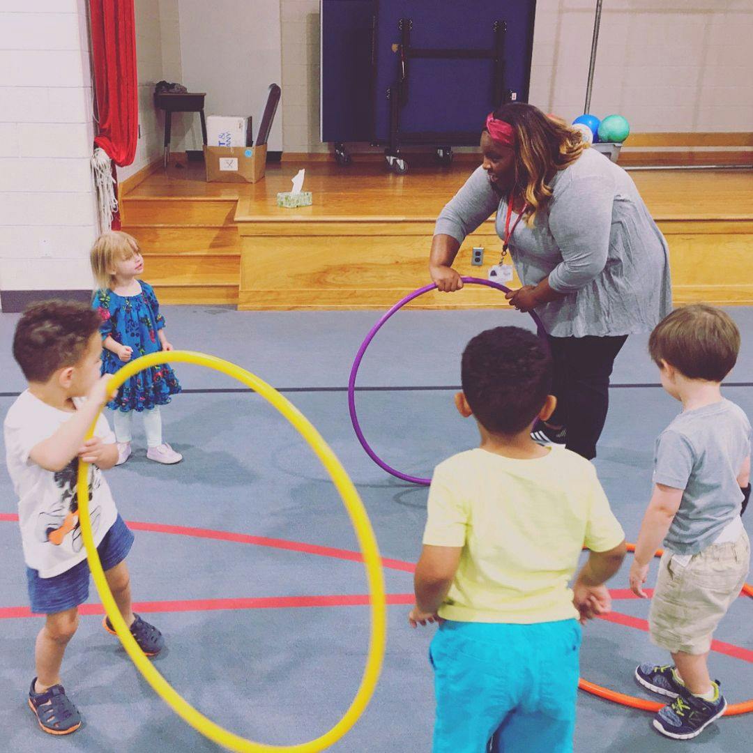 Adult and children playing with hula hoops