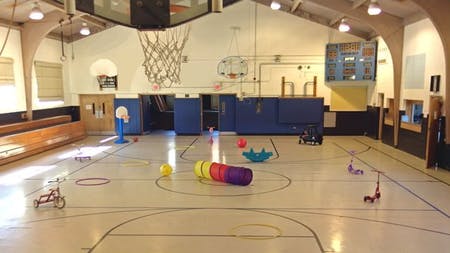 Gymnasium with various play equipment on the court