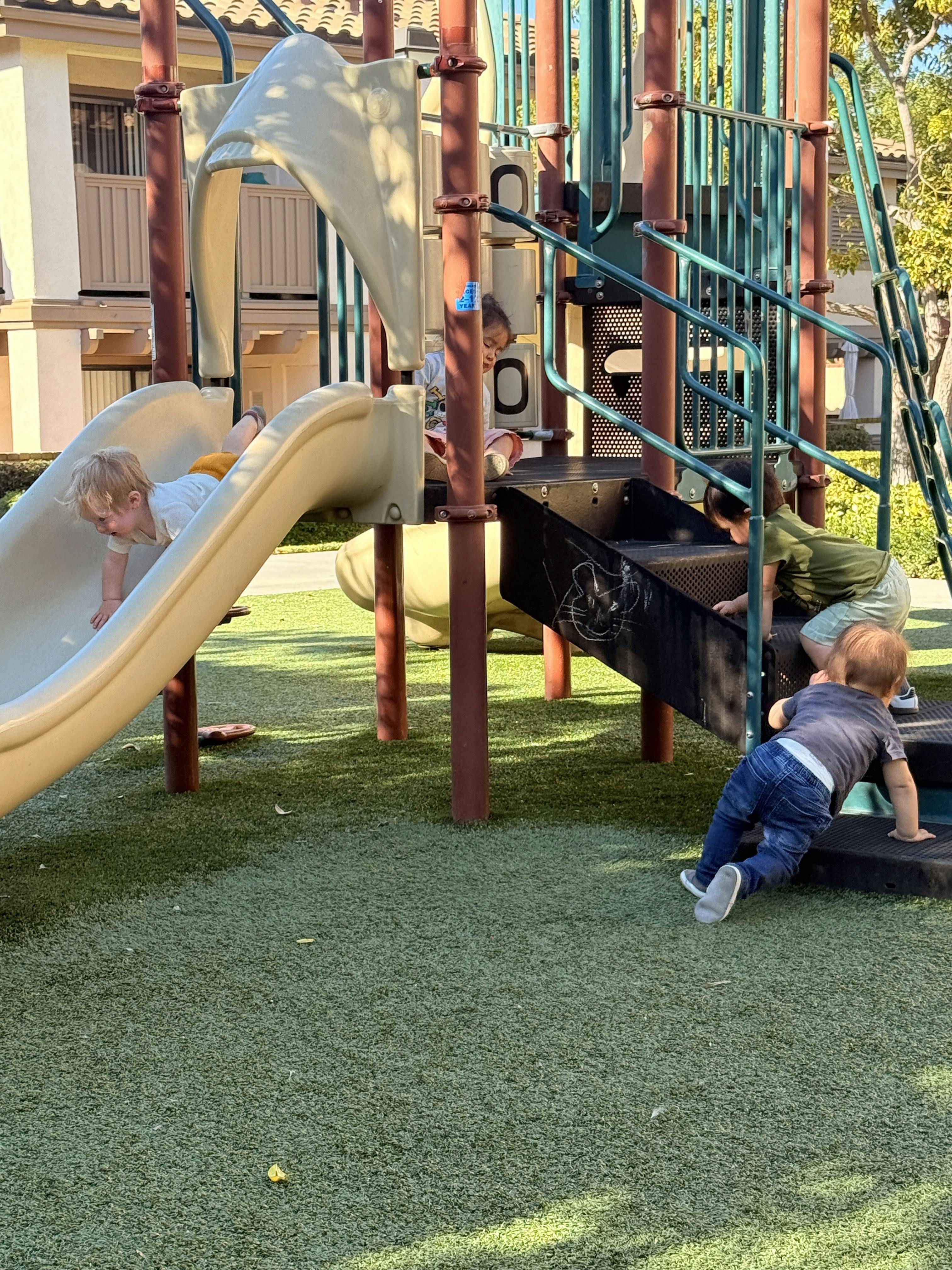 Children on a playground structure with slides and stairs