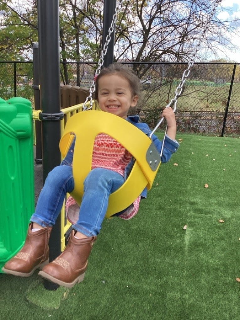 Child in a yellow swing on a playground