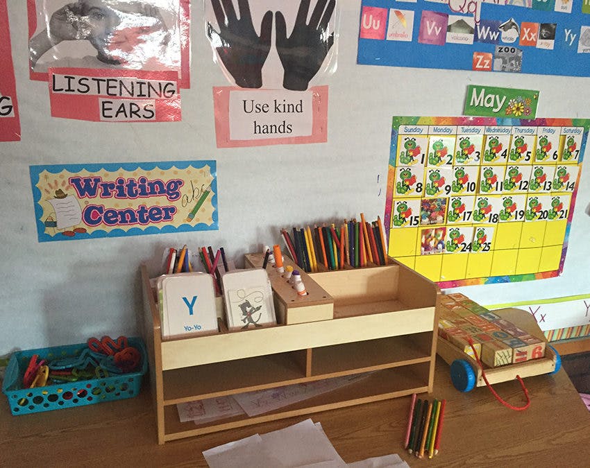 Writing Center sign above a wooden organizer with pencils and cards