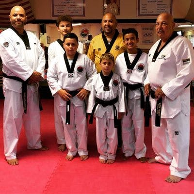 Group of people and children in taekwondo uniforms