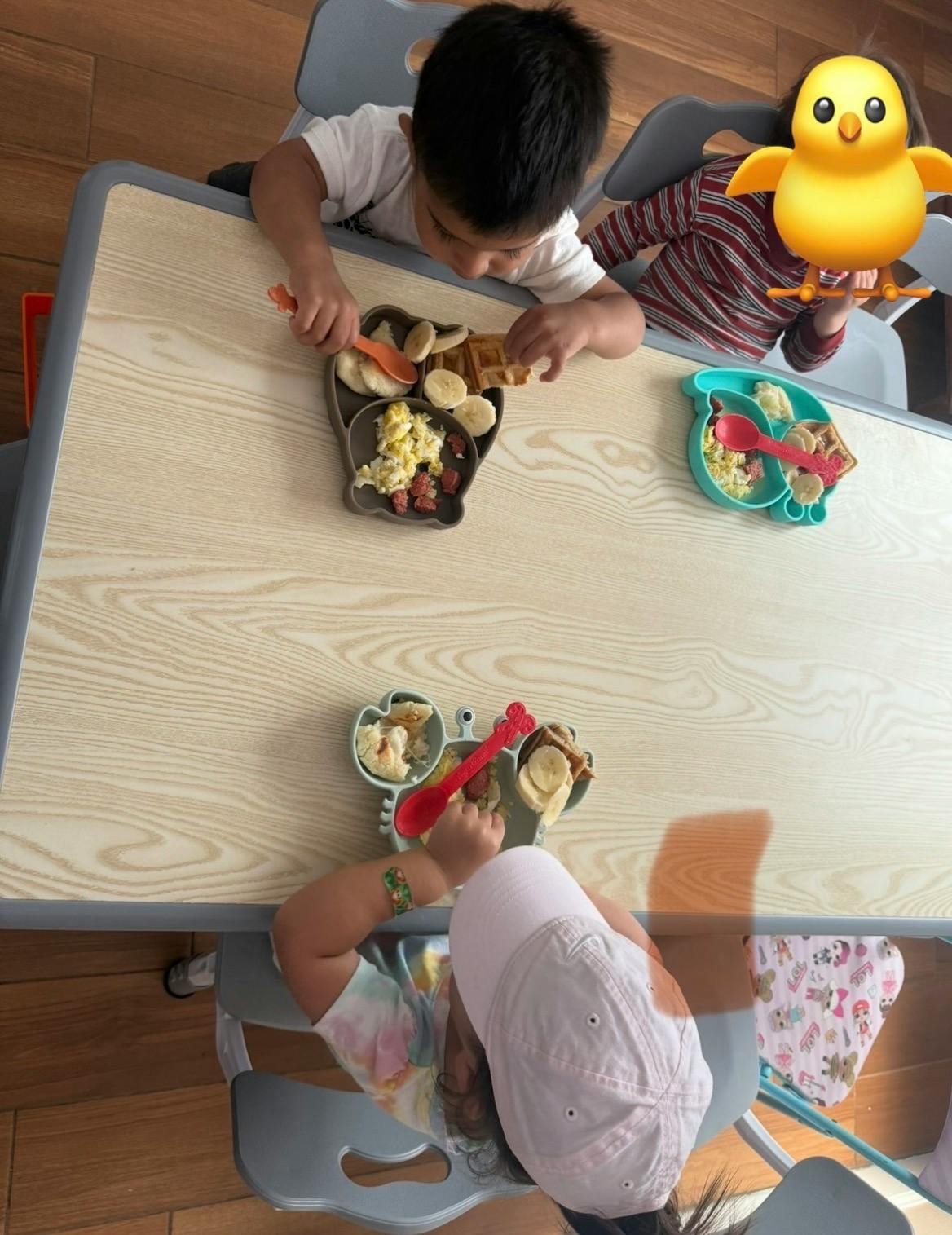 Three children eating breakfast at a table