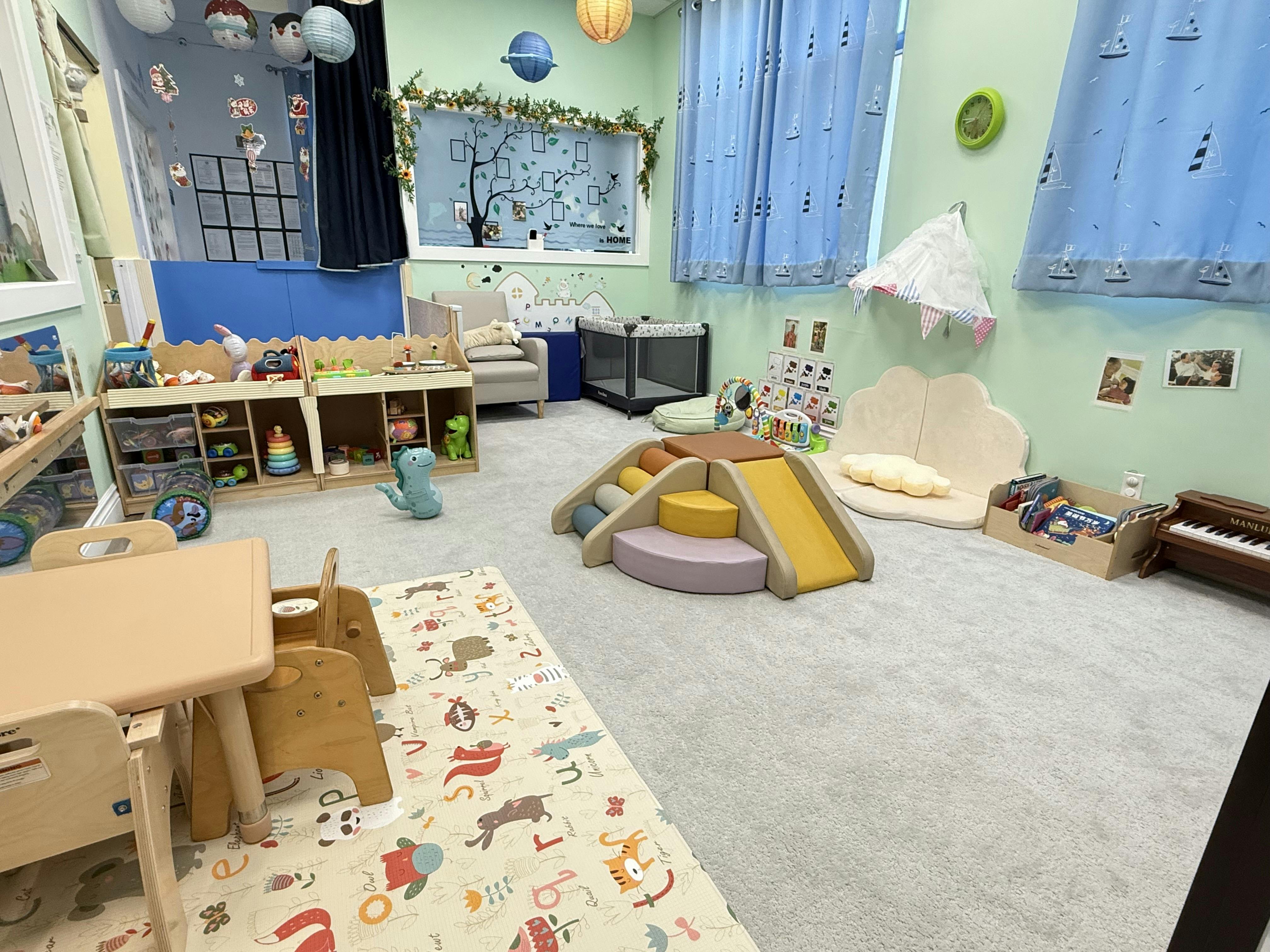 Indoor play area with small slide, tables, and toys