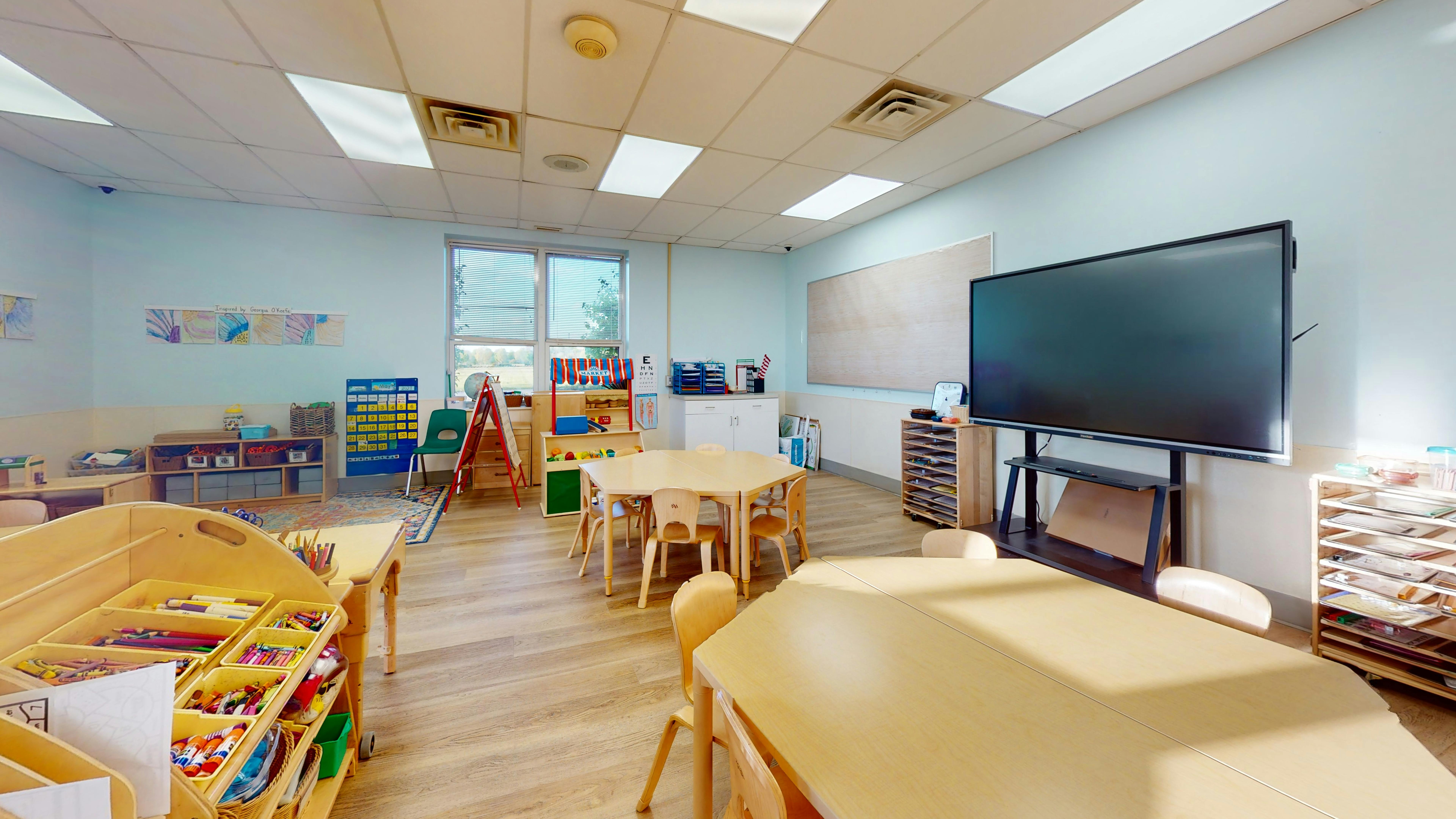 Empty classroom with small tables and chairs