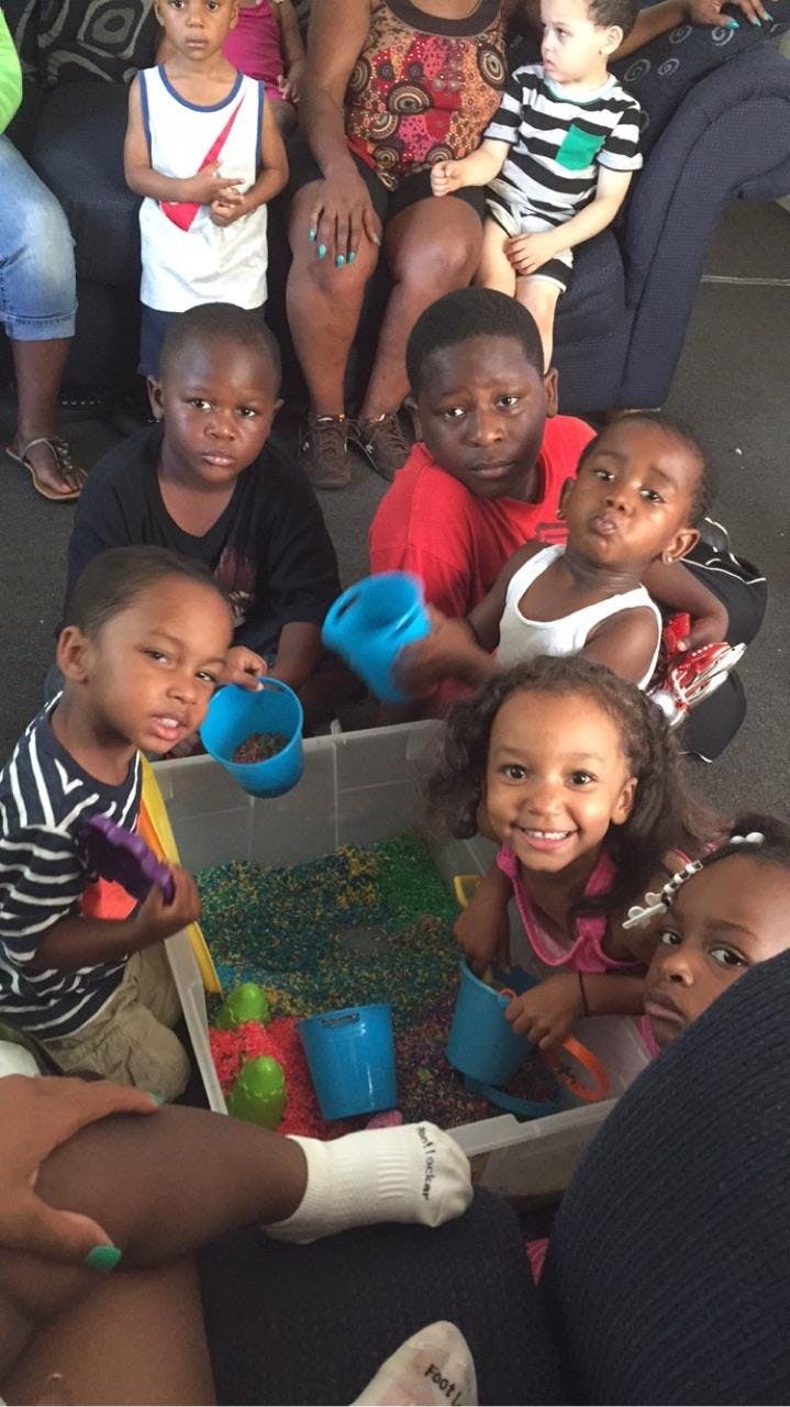 Children playing with sensory bin and cups