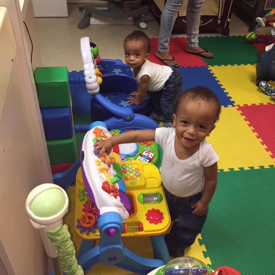 Two children playing with colorful toys on a mat