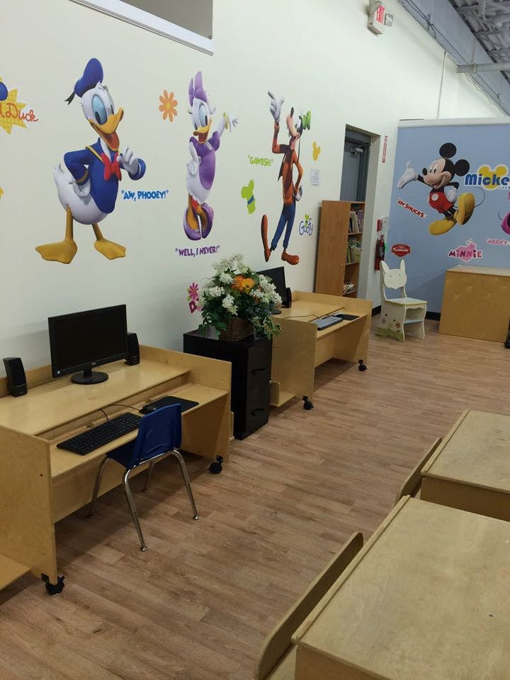 Classroom with computer desks and Disney character wall decals