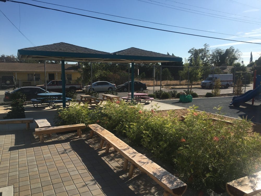 Outdoor seating area with picnic tables under awnings