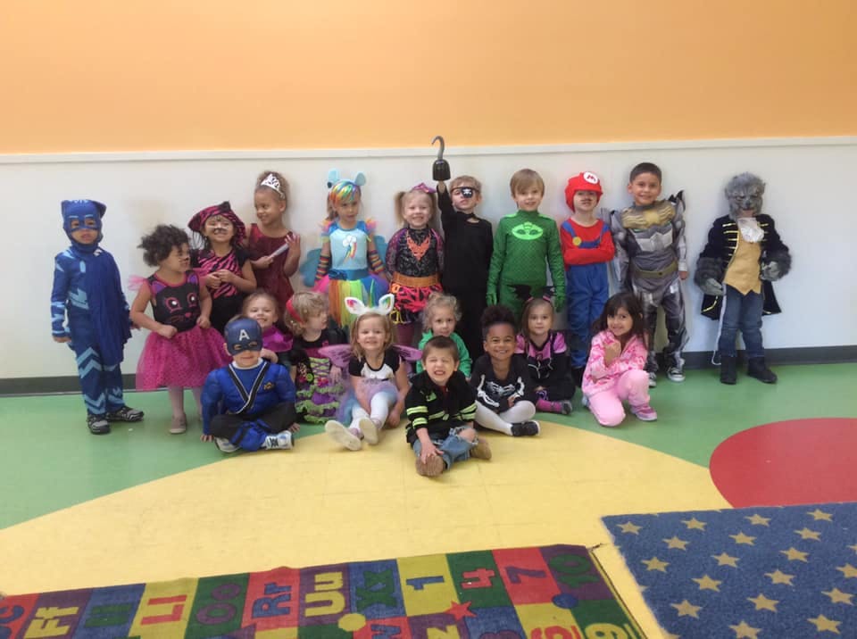 Group of children in various costumes standing and sitting