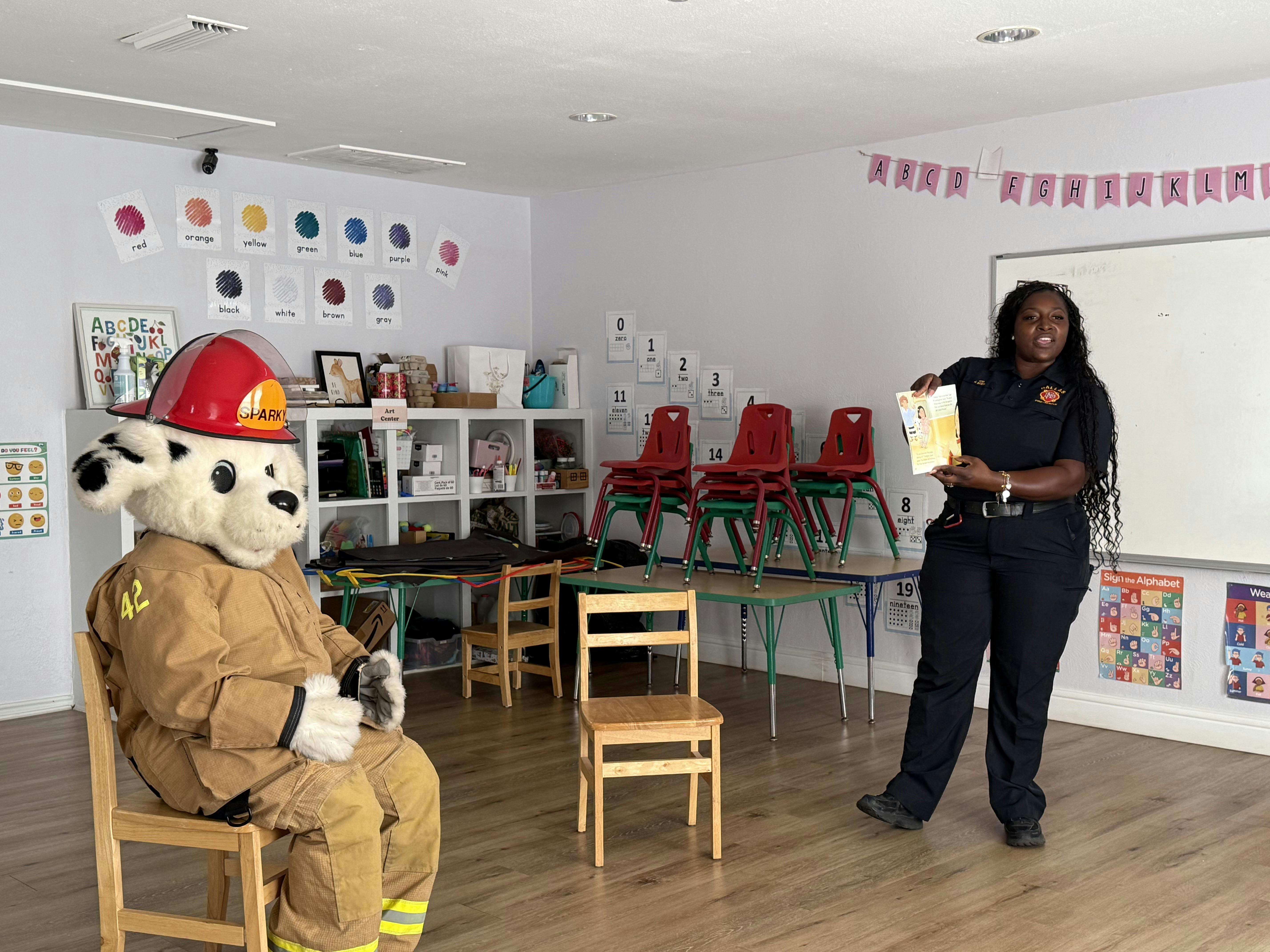 A firefighter and a mascot in a classroom