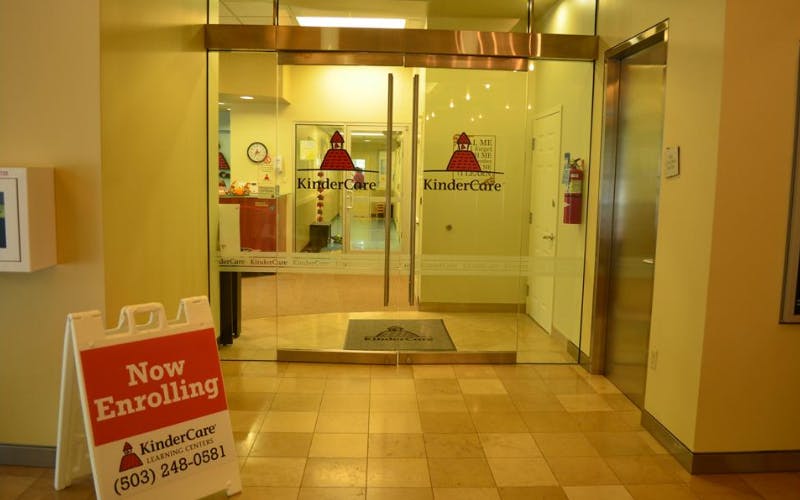 KinderCare entrance with a "Now Enrolling" sign