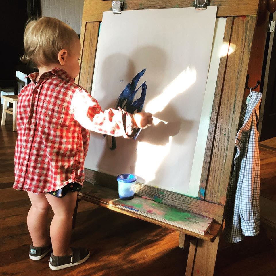 Child painting on an easel