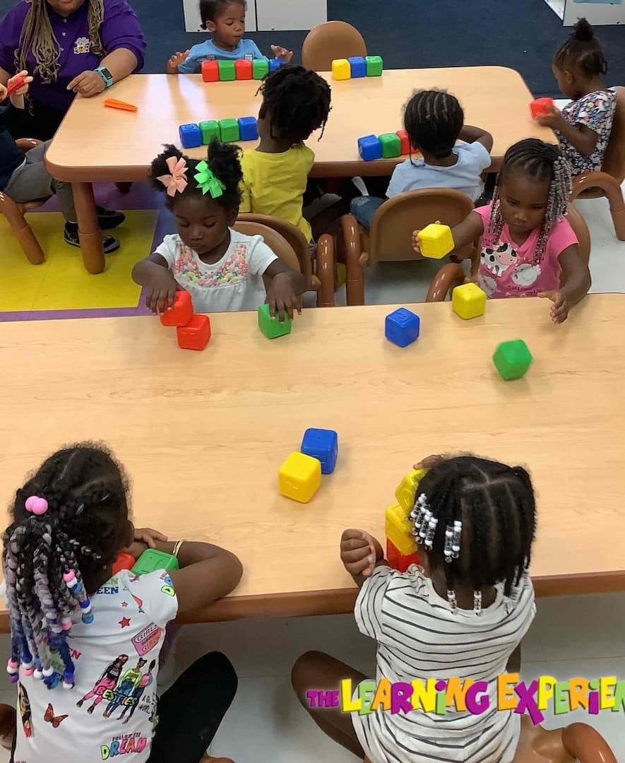 Children playing with colorful blocks at tables