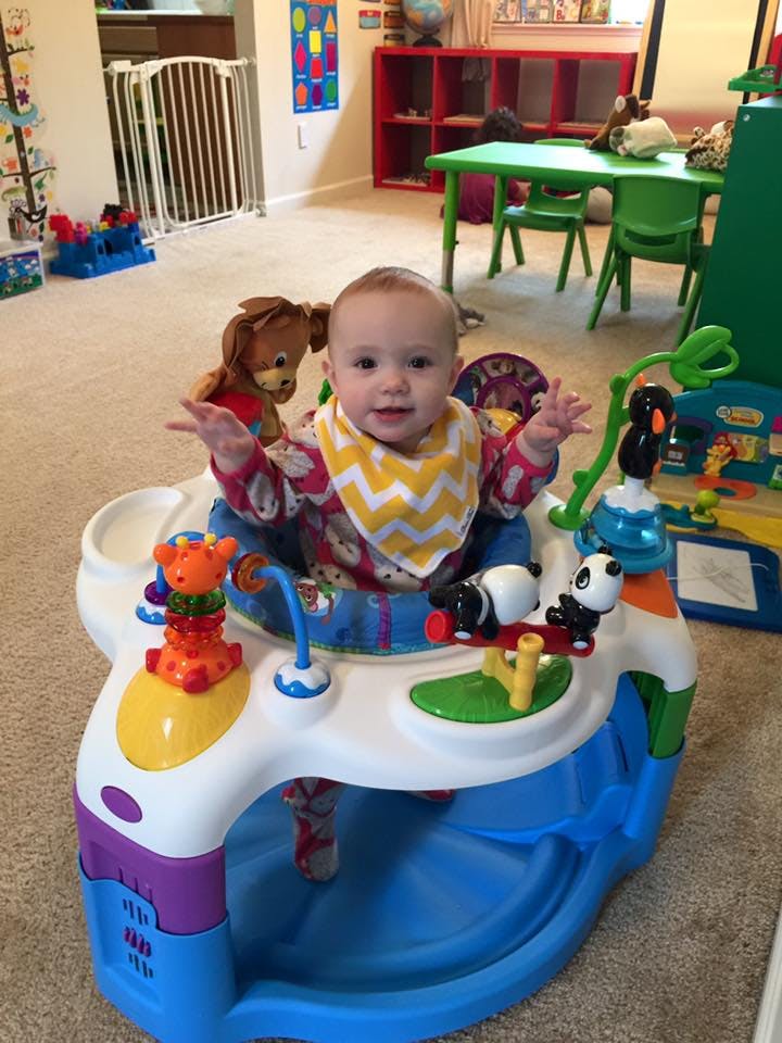 Child in a baby activity center with toys