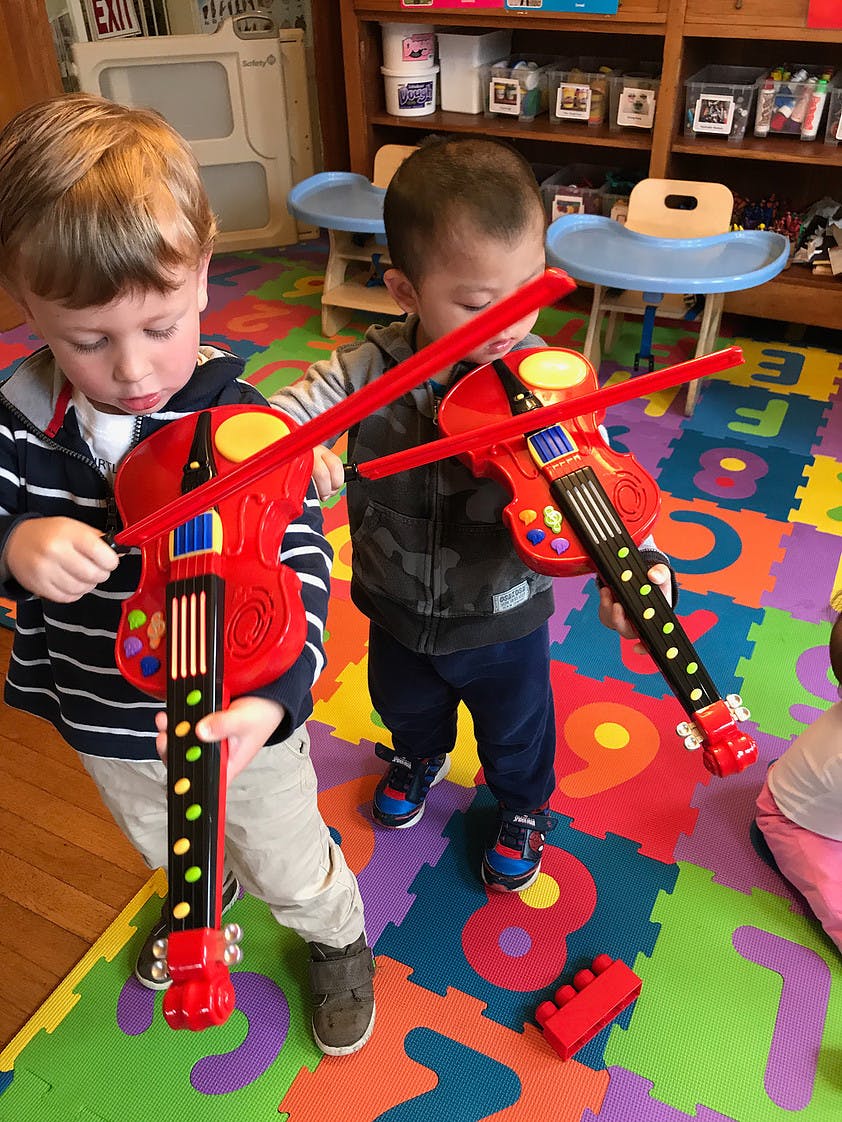 Two children holding toy violins