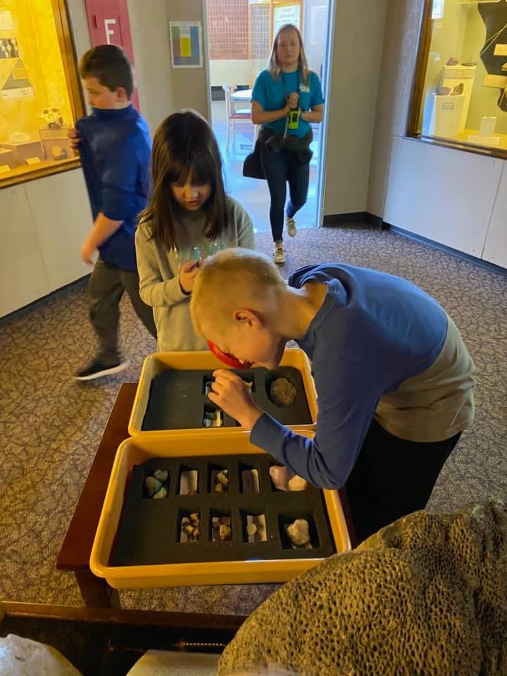 Child looking at rocks with a magnifying glass
