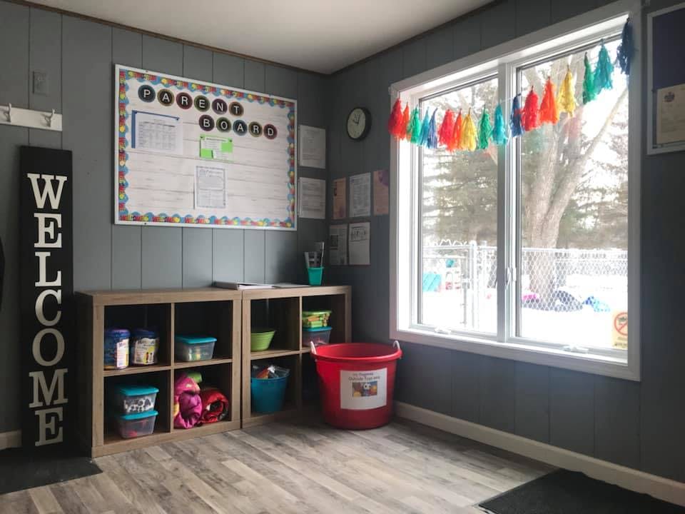 Classroom with bulletin board, storage cubbies, and window with a window overlooking snow