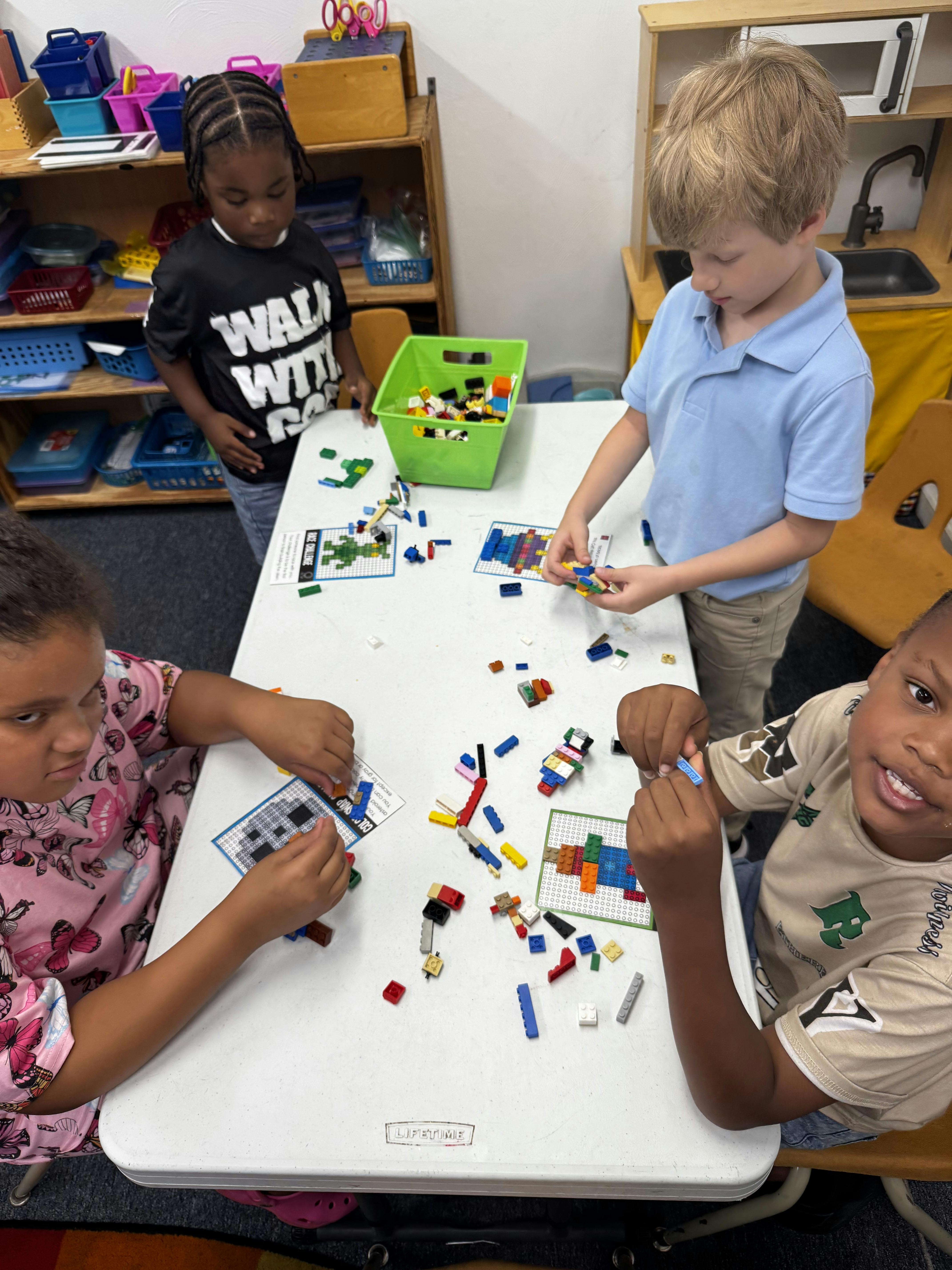 Four children playing with building blocks at a table