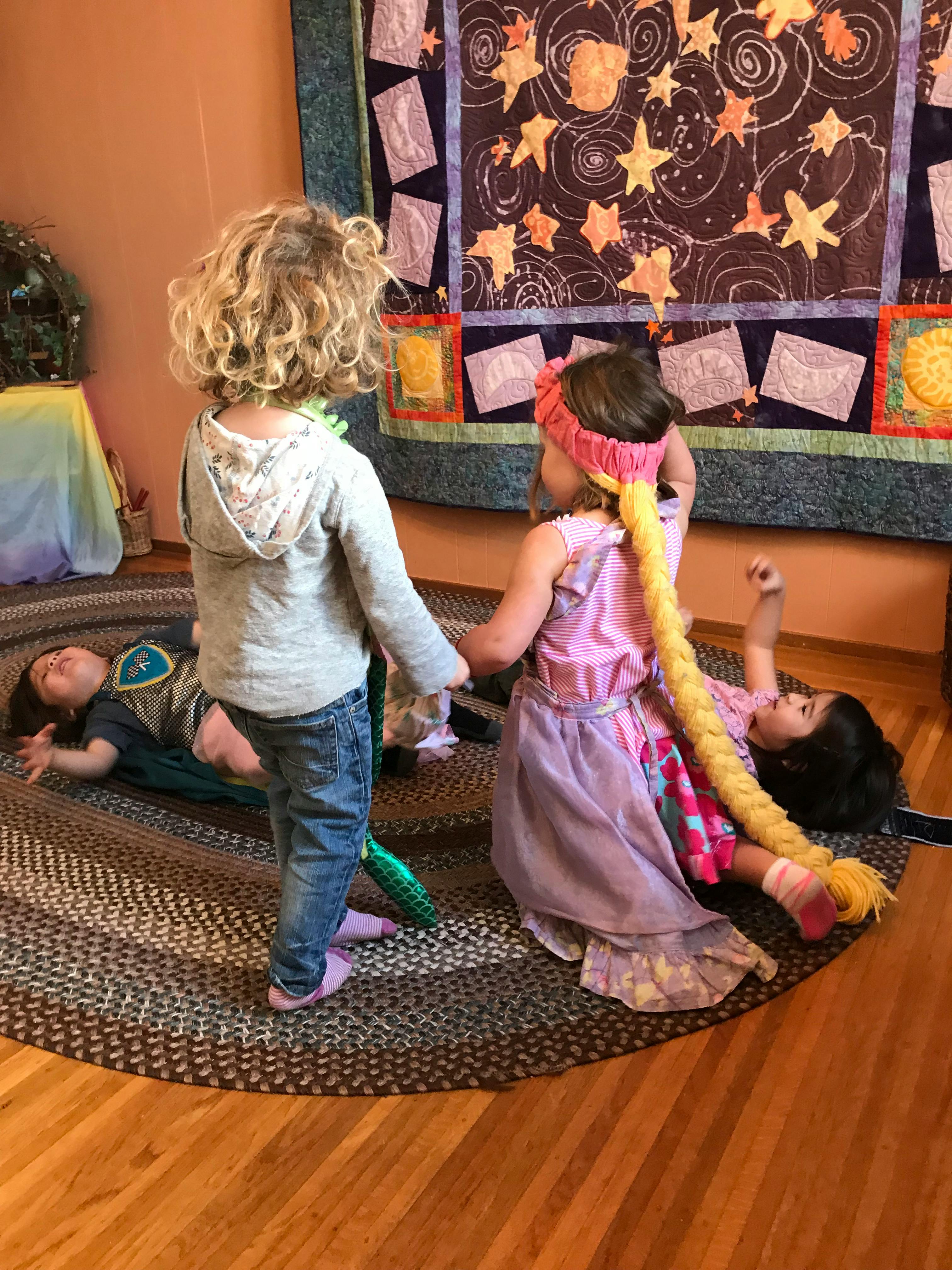 Three children playing on a rug