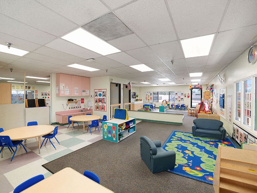 Classroom with small tables, chairs, and play areas