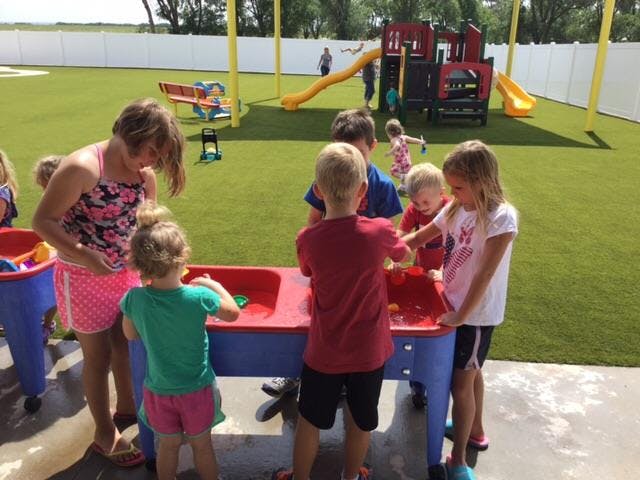 Children playing at a water table on a playground
