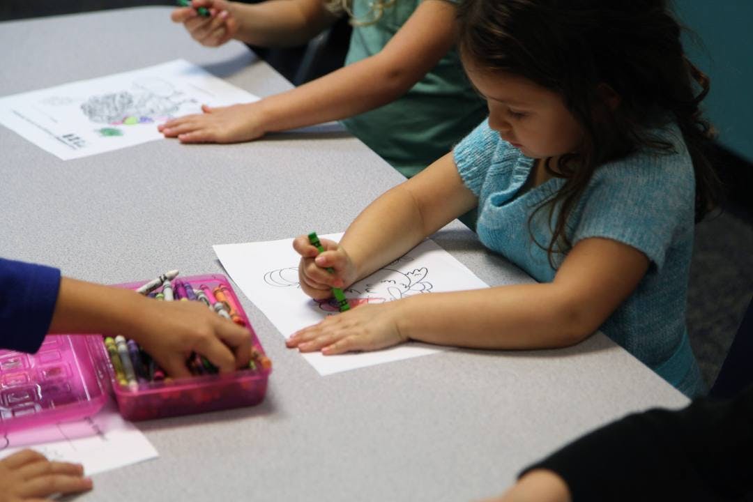 Child coloring on paper at a table