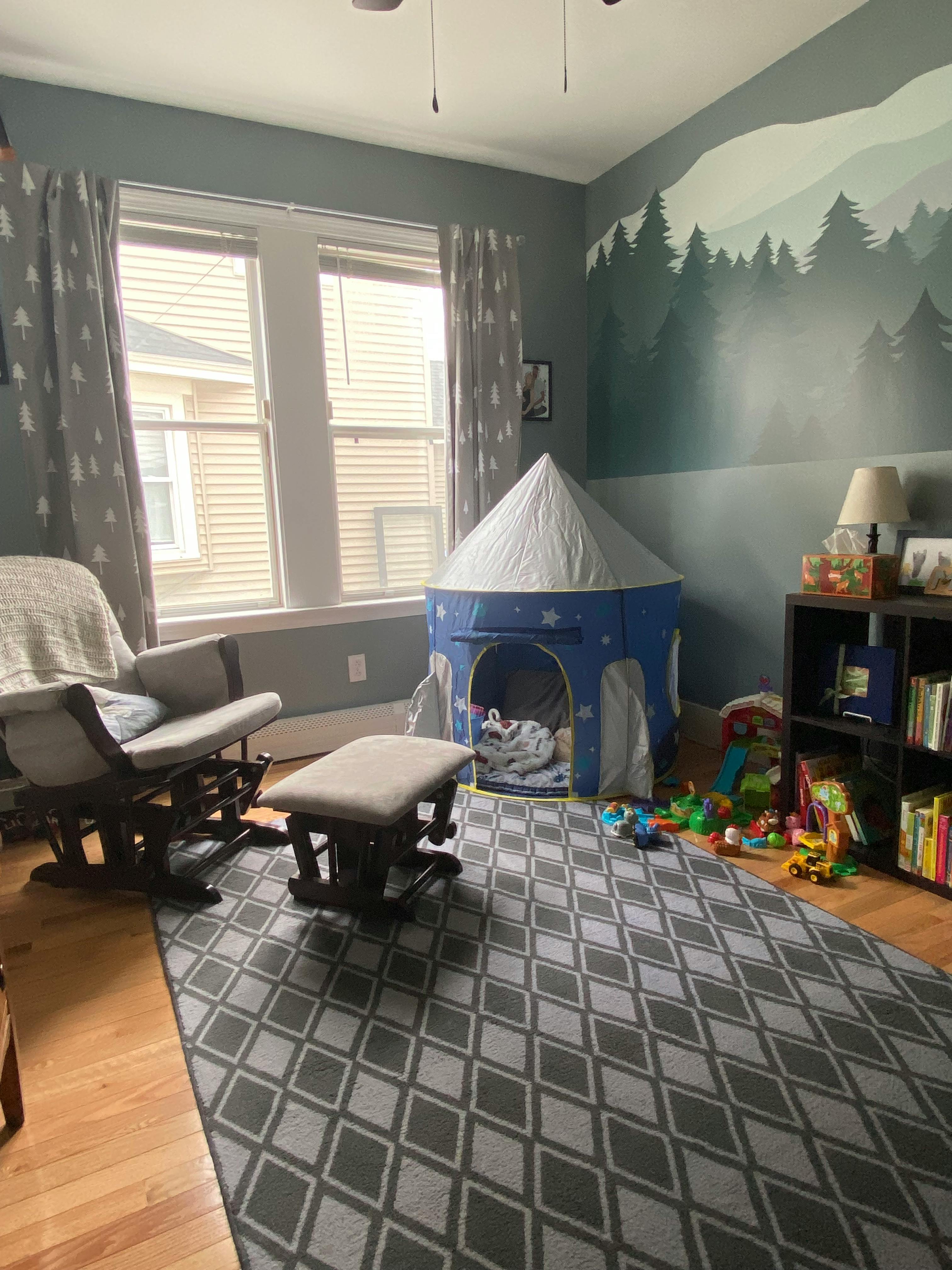 Nursery room with a rocking chair, play tent, and bookshelf