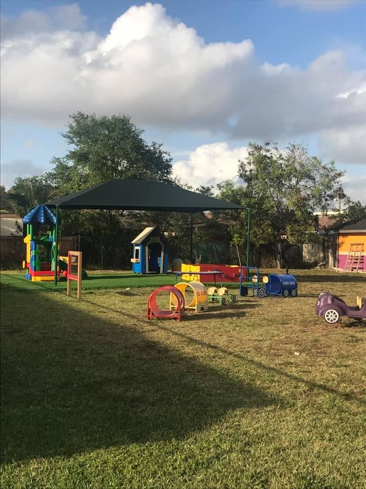 Outdoor playground with colorful play structures and a shade canopy