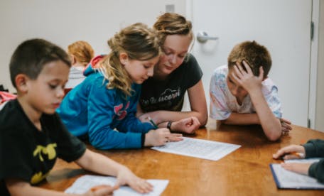 People and children looking at papers on a table