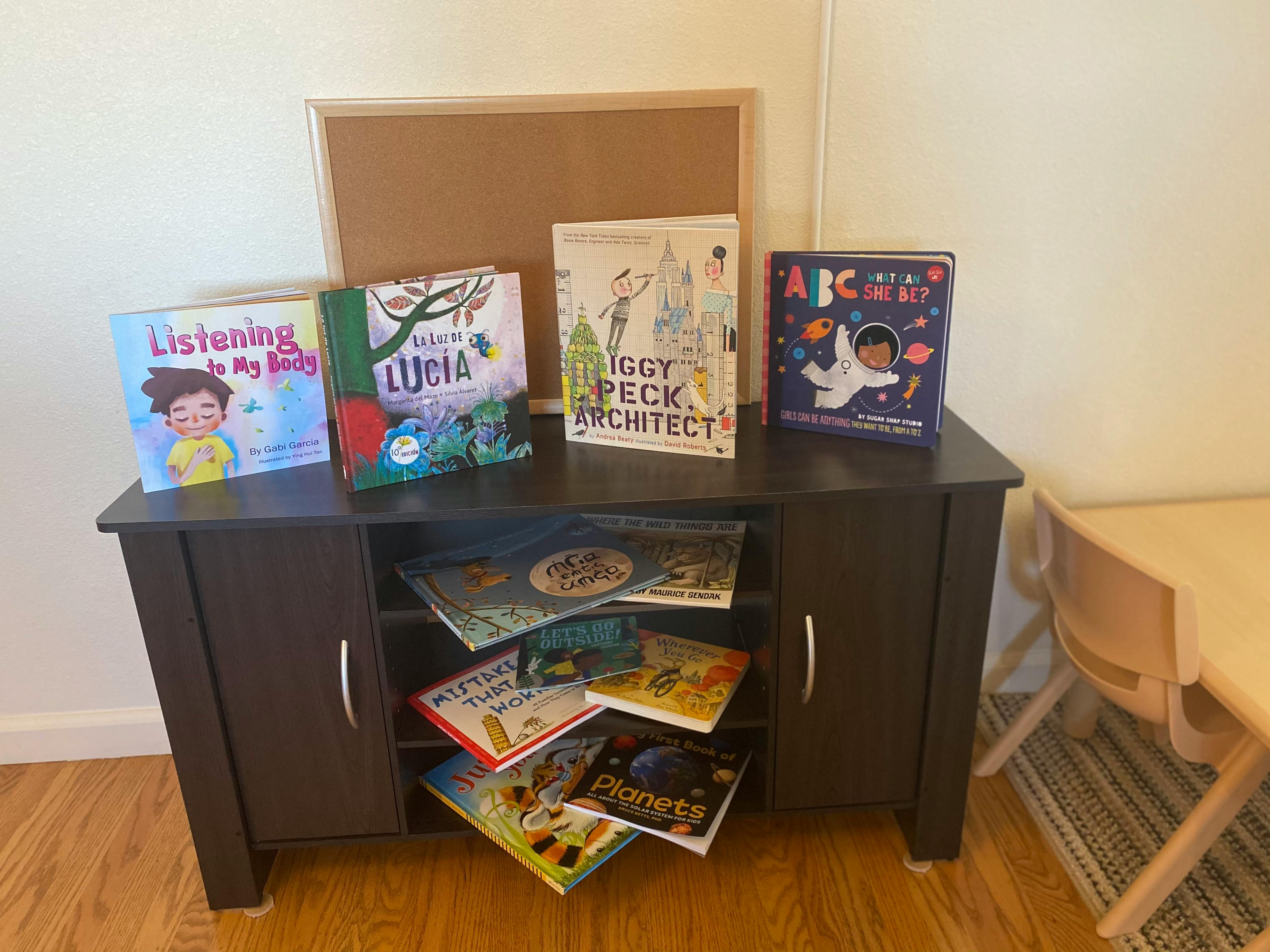 Children's books displayed on a dark brown cabinet