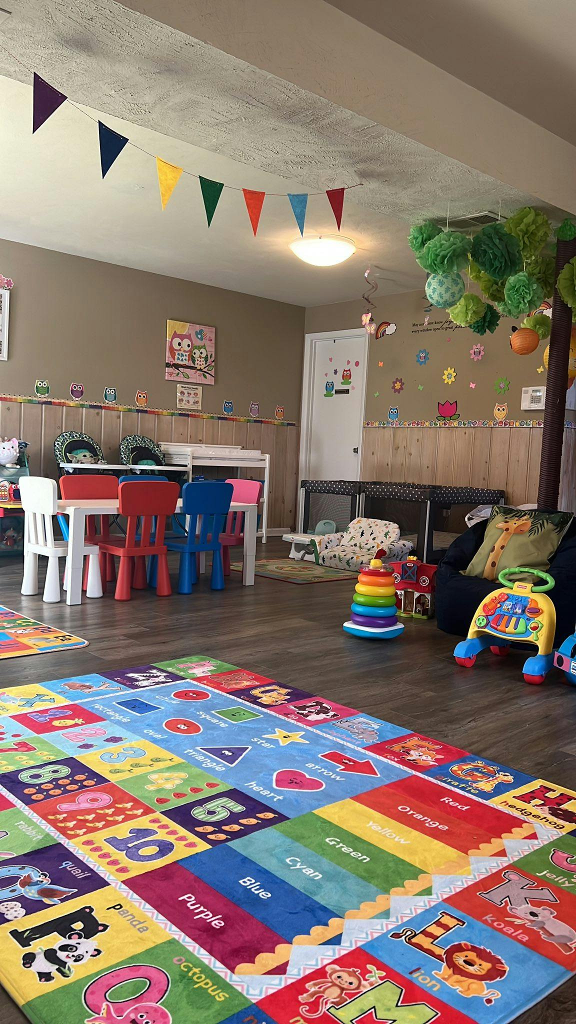 Colorful children's play area with a rug, small table and chairs, and toys