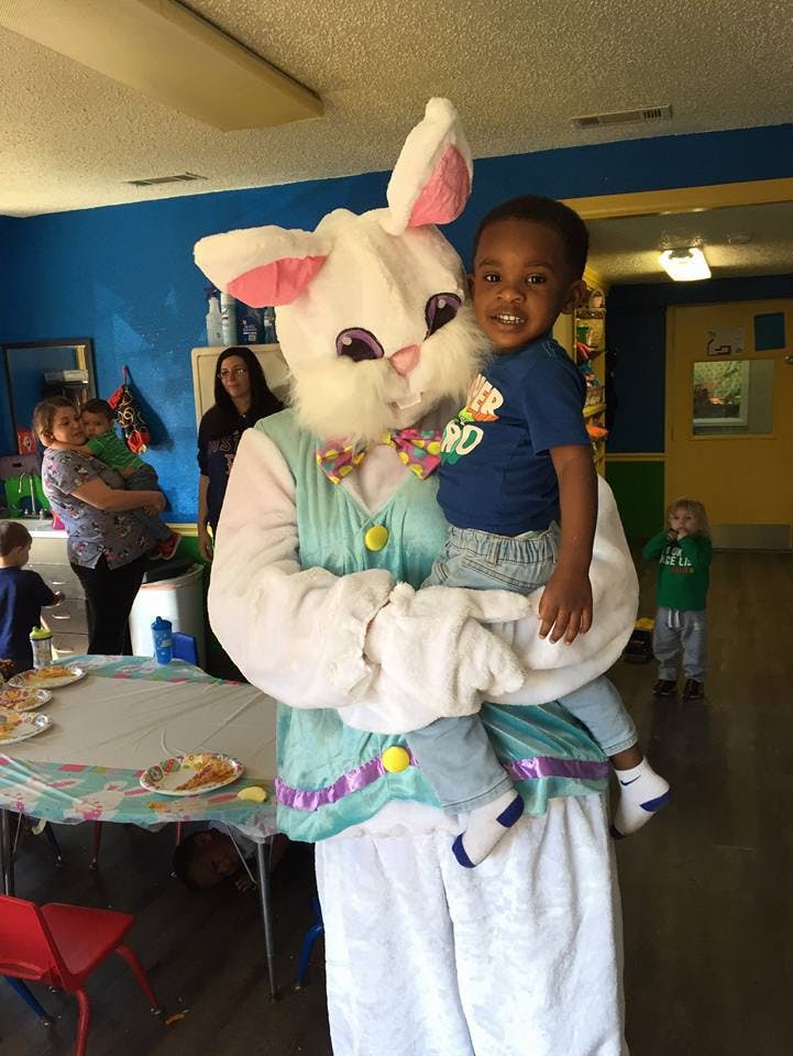 Person in bunny costume holding a child