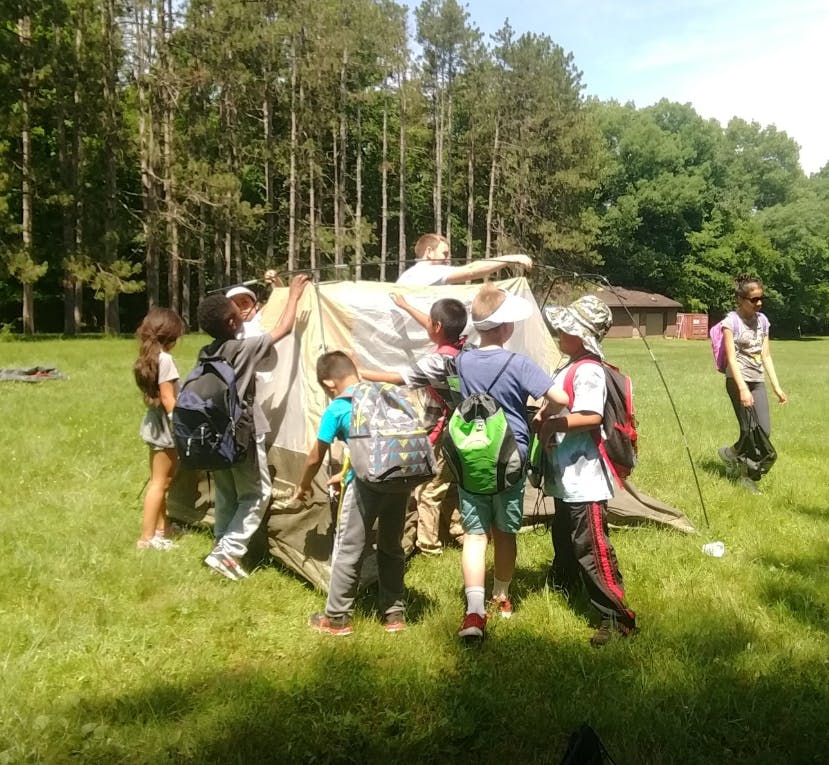 Children setting up a tent outdoors