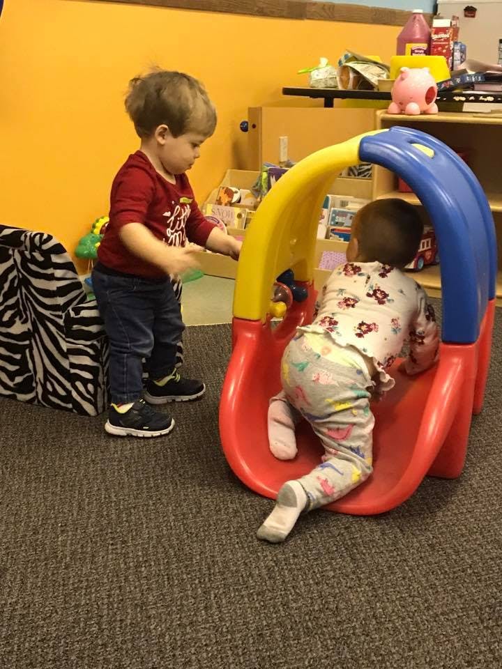 Two children playing with a small slide