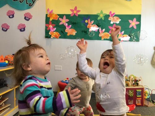 Children playing with bubbles in a classroom