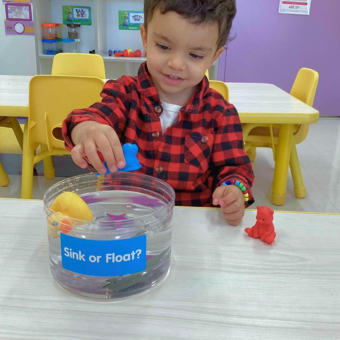 Child playing with a "Sink or Float?" water activity
