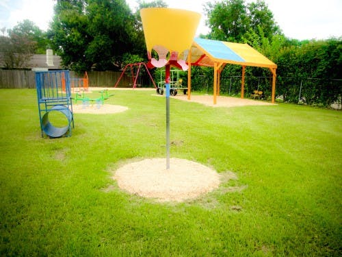 Playground with various equipment including a yellow funnel and blue tunnel