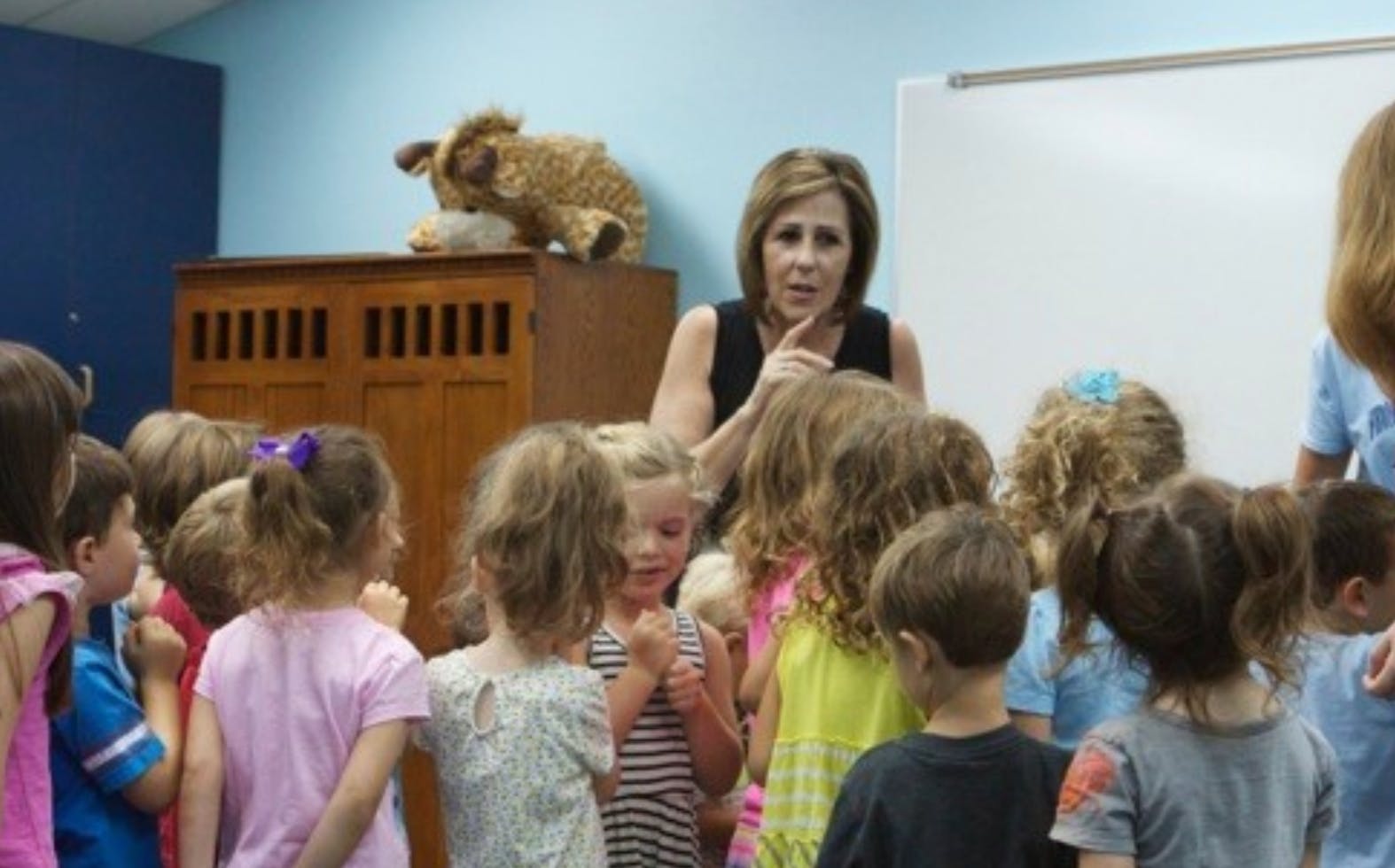 Adult person speaking to a group of children