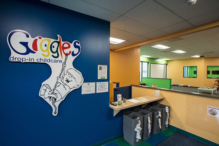 Giggles drop-in childcare sign on a blue wall