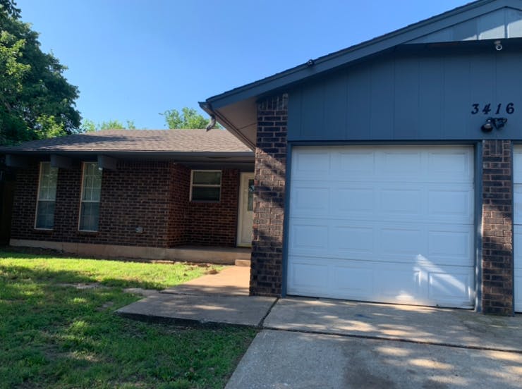 Brick house with a blue facade and white garage door