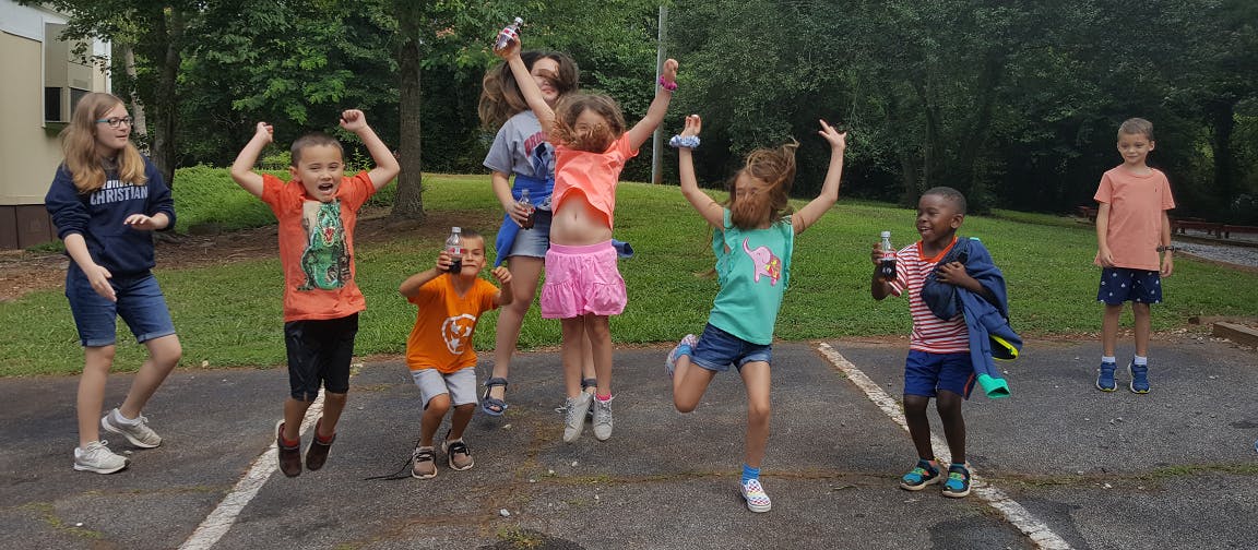 Group of children jumping and posing outdoors