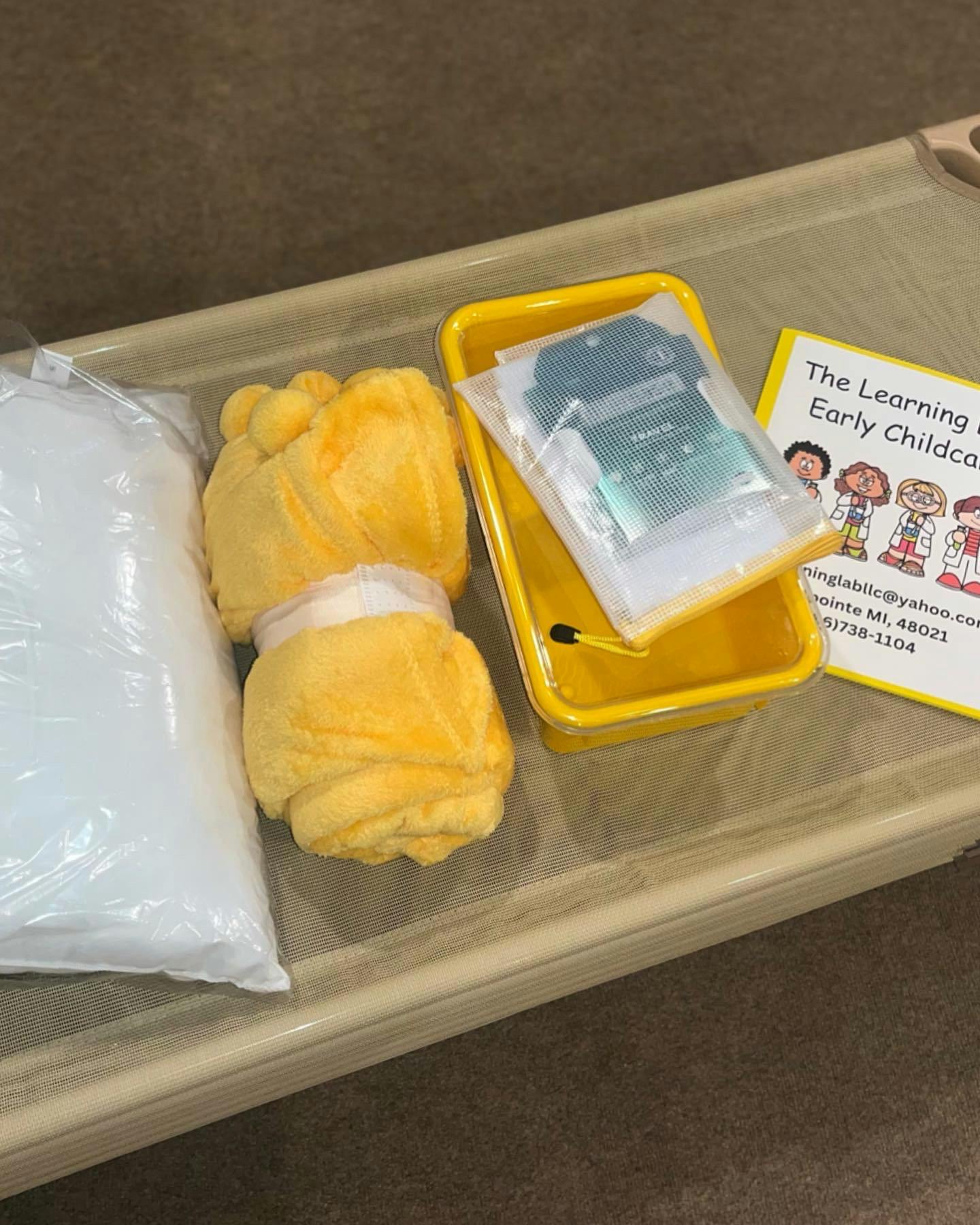 Bag of white material, yellow fabric, yellow tray with items, and a paper