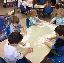 Children playing with flour on a table