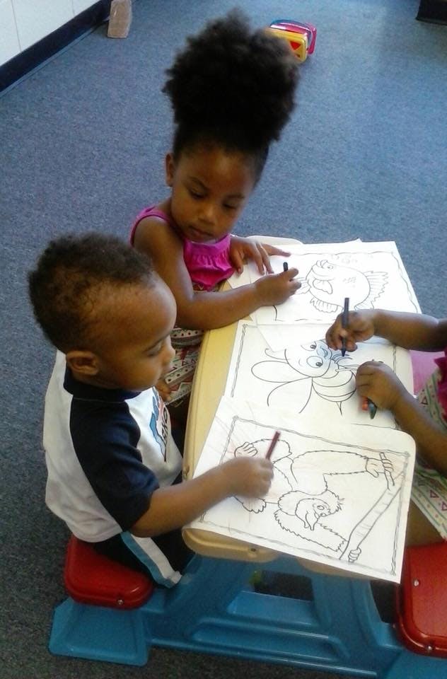 Children coloring at a small table